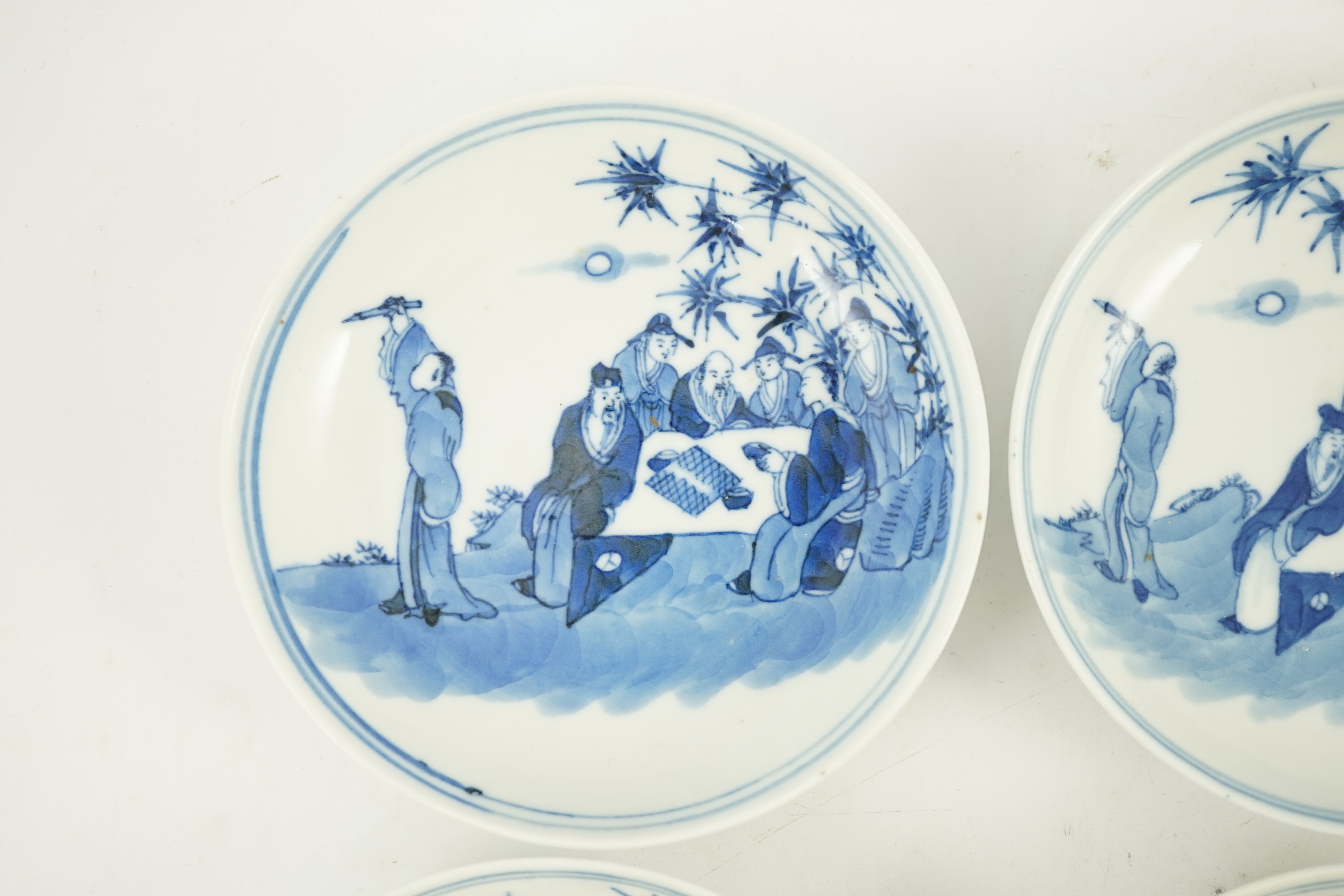 A set of six Chinese ‘Seven Sages of the Bamboo Grove’ saucer dishes, Kangxi marks but late 19th century, 12.3cm diameter